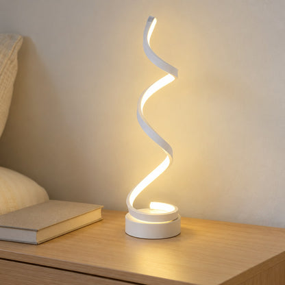 Lámpara espiral cálida sobre mesa de madera