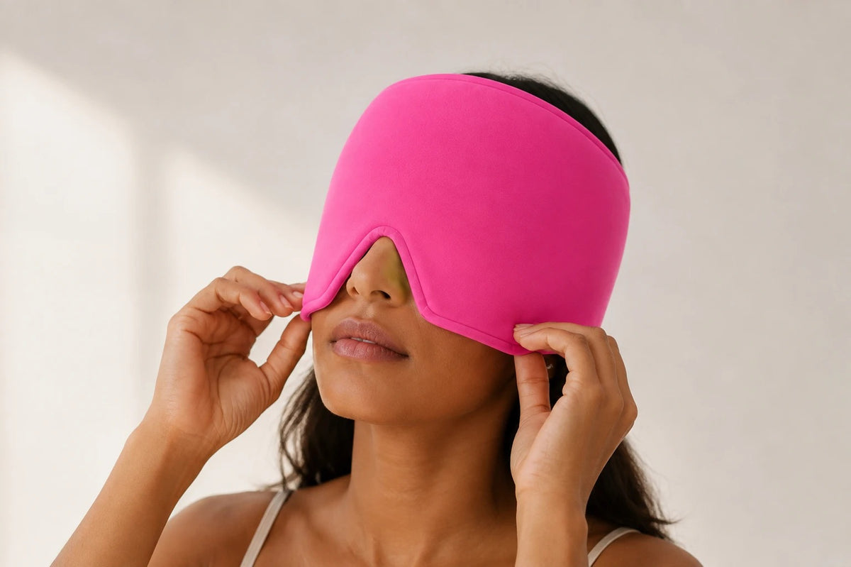 Mujer colocándose el gorro de gel rosa sobre los ojos