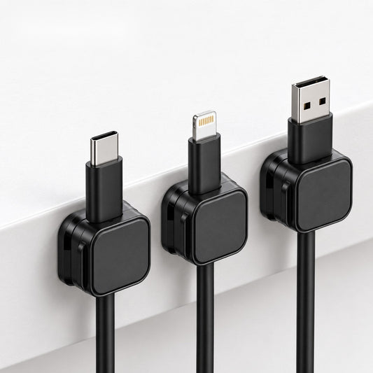 Tres organizadores magnéticos negros con cables USB-C, Lightning y USB en el borde de un escritorio blanco