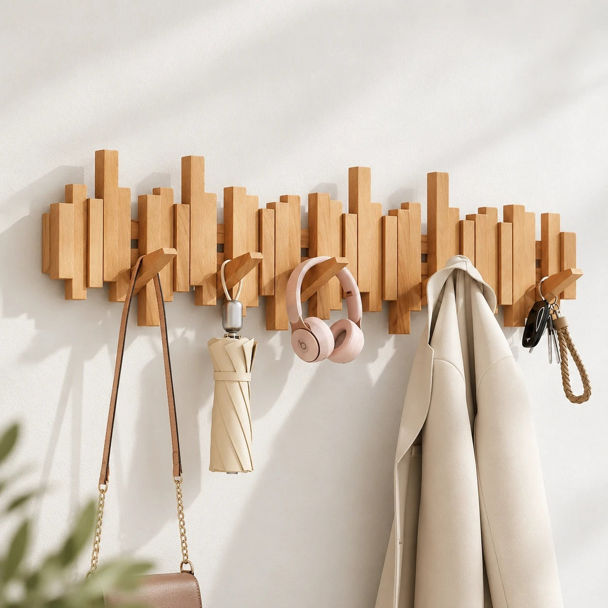 Perchero de pared de haya con bolso, paraguas, auriculares y abrigo colgados